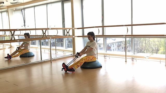 Photo of Horizontal pull using resistance band with lifting legs on bosu exercise