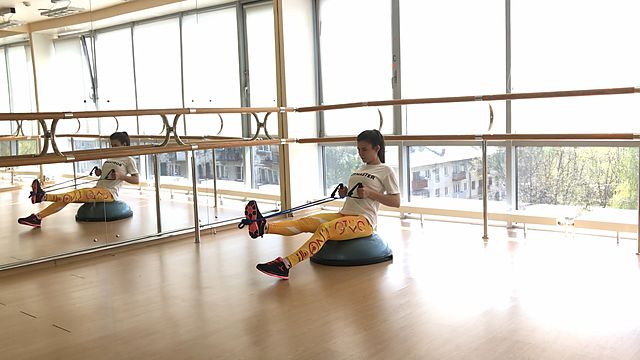 Photo of Horizontal pull using resistance band with lifting legs on bosu exercise