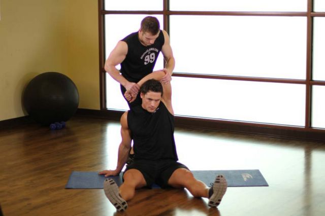 Фото упражнения Растягивание широчайших мышц спины с напарником
