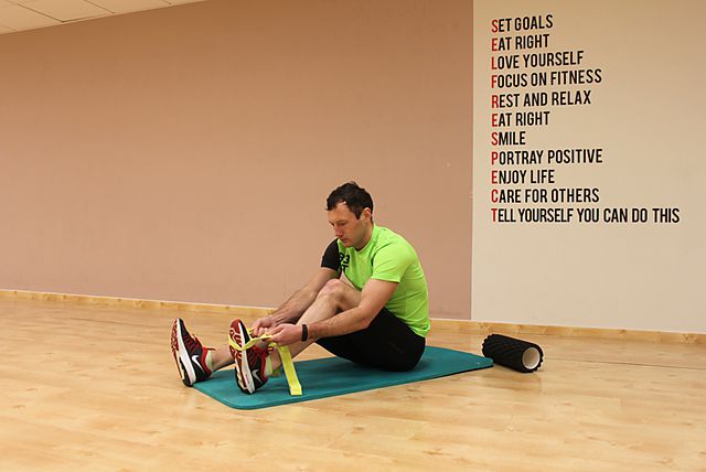 Фото упражнения Растяжка икр и мышц задней поверхности бедра сидя на полу